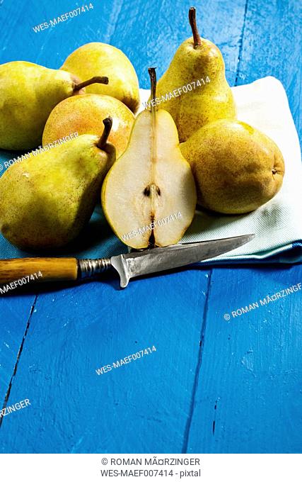 Williams pears and knife on blue wooden table