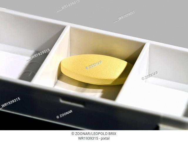 medicin box with yellow tablet