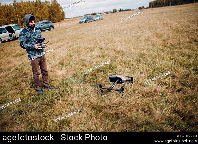 Man pilot controlling quadcopter drone with remote controller pad