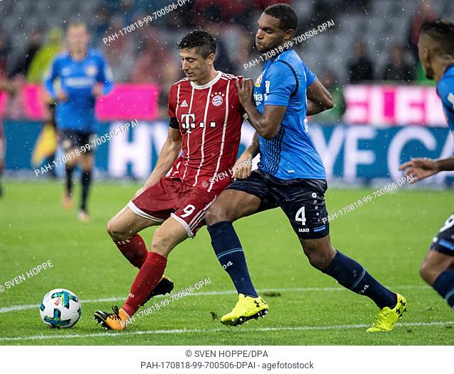 Muenchen's Robert Lewandowski (L) and Leverkusen's Aleksandar Dragovic vie for the ball during the German Bundesliga soccer match between Bayern Muenchen and...