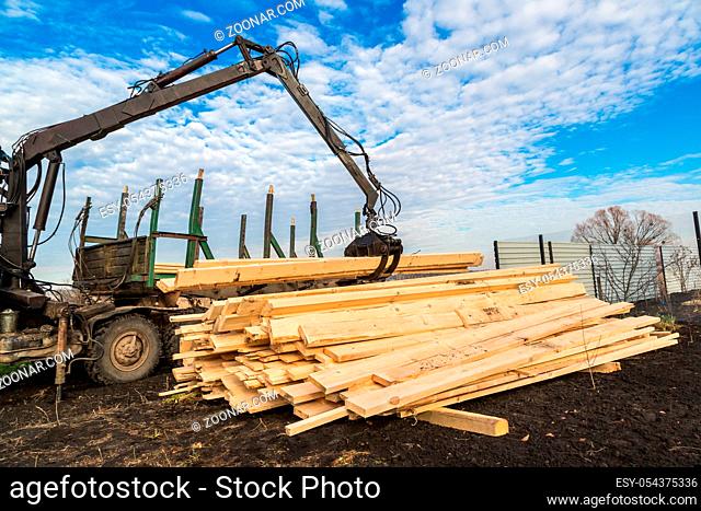 Tree log hydraulic manipulator - tractor on sunny day
