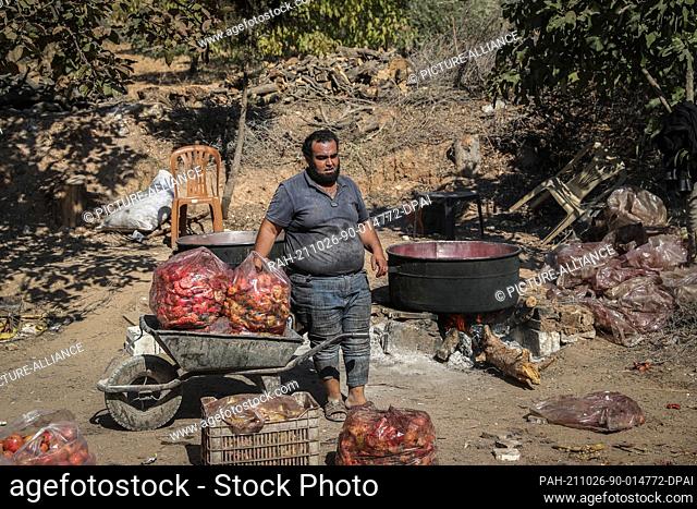 24 October 2021, Syria, Al-Alani: A Syrian worker makes pomegranate molasses in the Al-Alani village on the Syrian-Turkish border near Idlib province