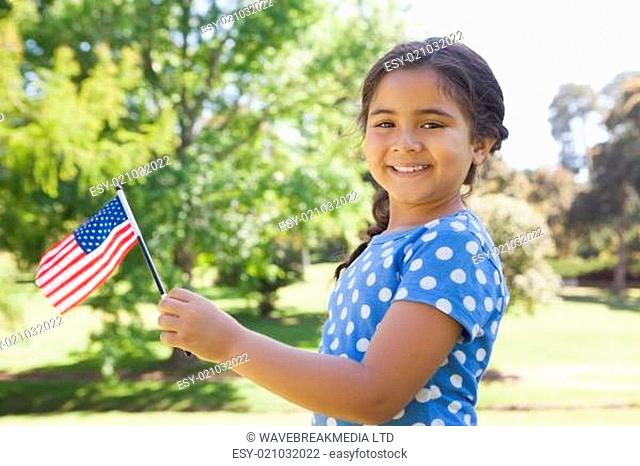 Girl holding the American flag at park