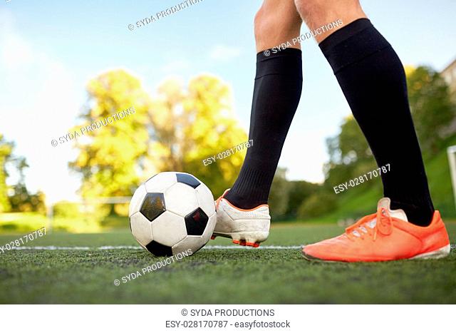 sport, football and people - soccer player playing with ball on field