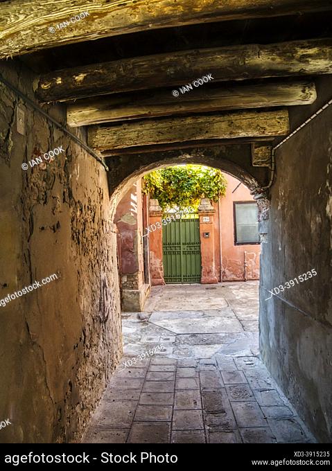 narrow tunnel leading to green door, Murano Island, Venice, Italy