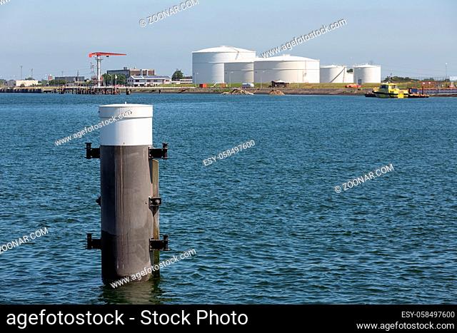 Dutch harbor Vlissingen with steel bollard and oil storage tanks