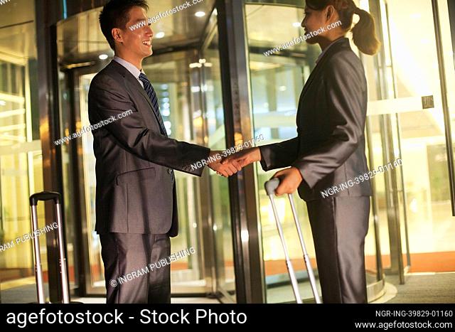 Young business people handshaking outside of the office