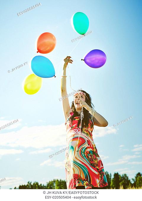 Beautiful pregnant young woman feeling lovely and relax outdoors and she plays with a balloons