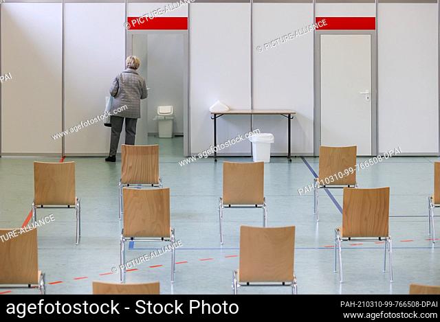 10 March 2021, Saxony, Plauen: A woman peers into a vaccination booth at the second vaccination center in Vogtland, which opened on the same day