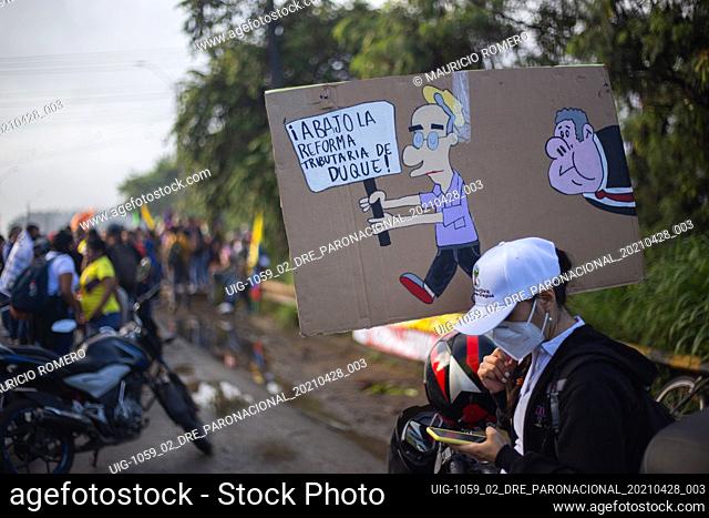 A demonstrator carries a sign with a cartoon of former president of Colombia Alvaro Uribe with a sign that reads ""No to Duque's tax reform"" as demonstrators...