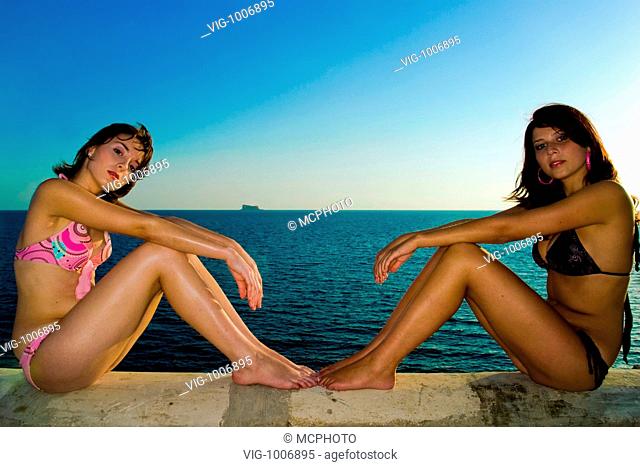 Two gorgeous young girls relaxing by the ocean during a hot summers day in Malta in their bikinis. - 13/08/2007