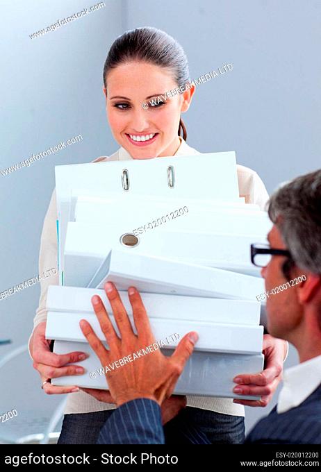 Elegant businesswoman carrying a stack of folders
