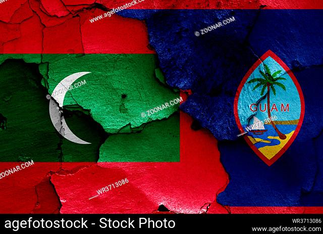 flags of Maldives and Guam painted on cracked wall