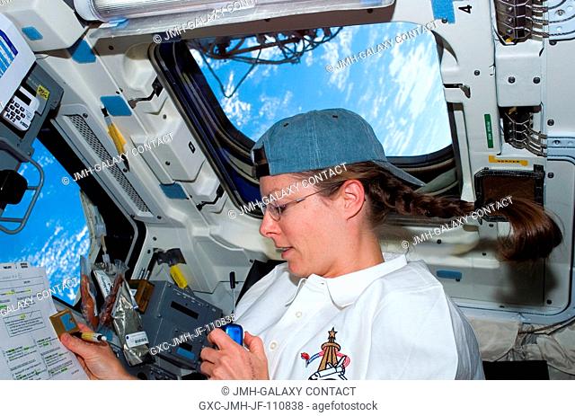 Astronaut Tracy Caldwell, STS-118 mission specialist, uses a communication system on the aft flight deck of Space Shuttle Endeavour during flight day four...
