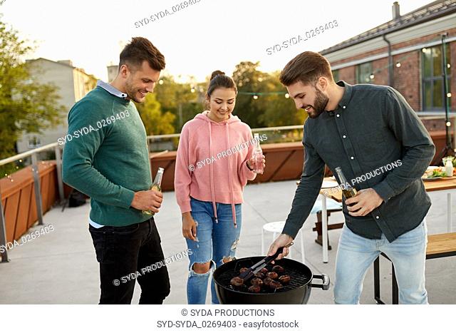 happy friends having bbq party on rooftop