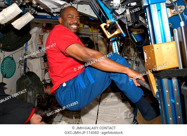 Astronaut Leland Melvin, STS-129 mission specialist, exercises using the advanced Resistive Exercise Device (aRED) in the Unity node of the International Space...