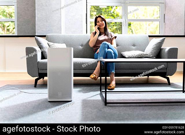 Woman In Living Room Using Air Cleaner And Humidifier
