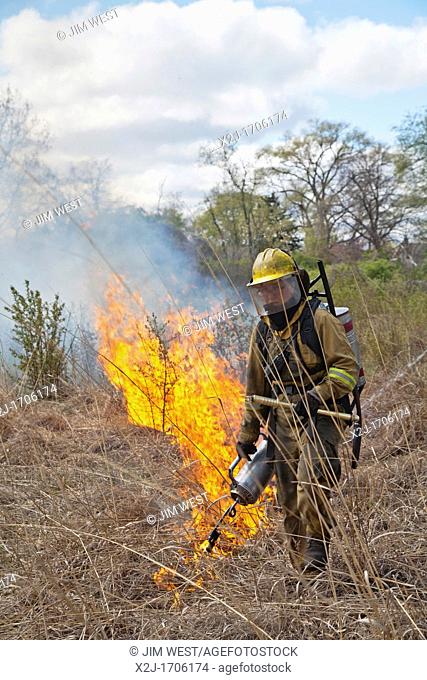 Detroit, Michigan - Woman wears protective clothing as she helps burn parts of River Rouge Park with the aim of eliminating invasive species  After the fire