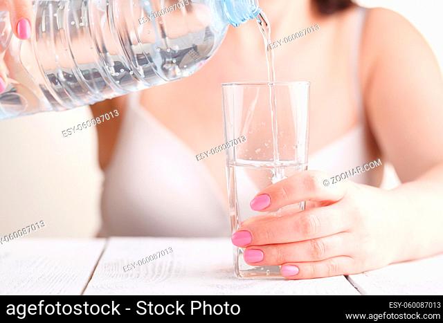 Pouring water from bottle into glass