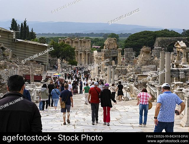 PRODUCTION - 11 May 2023, Turkey, Selcuk: Numerous tourists visit the ancient city of Ephesus with the Curete Street. In the background is the Celsus Library