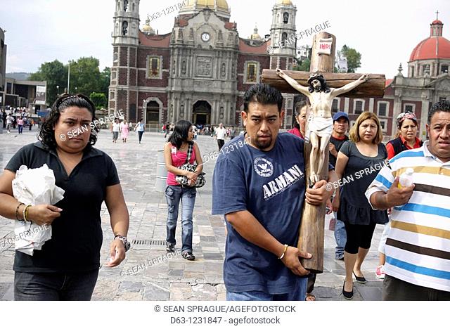 Mexico, Mexico City, Basilica of Guadalupe. Pilgrims carrying religious statues which have been blessed by a priest