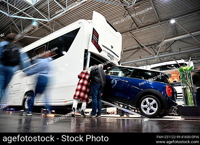 22 November 2023, Saxony, Leipzig: Visitors to the ""Touristik & Caravaning International 2023"" trade fair look at a motorhome that can also accommodate a car