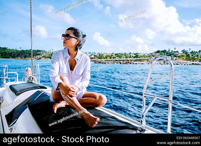 Small Curacao Island famous for day trips and snorkeling tours on white beaches blue clear ocean, Curacao Island in the Caribbean woman on sailing boat during a...