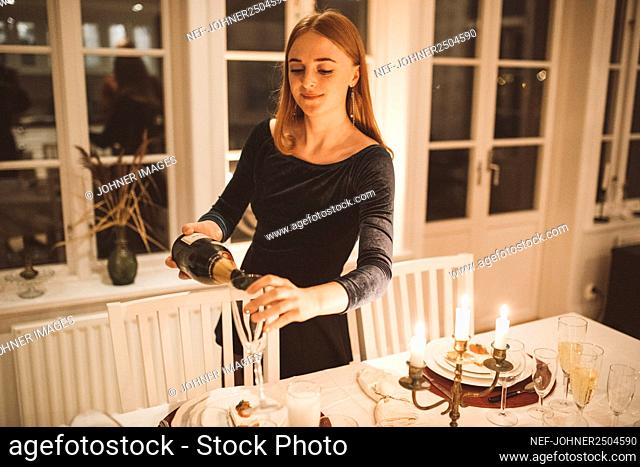 Young woman pouring champagne