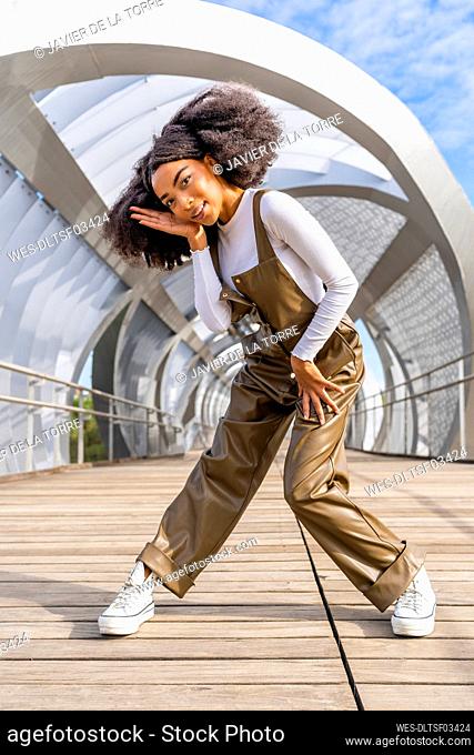 Young woman dancing on public bridge