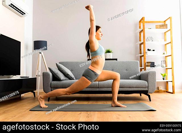 Woman In Fitness Wear Doing Lunges Exercise At Home