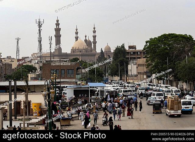 15 May 2020, Egypt, Cairo: People and vehicles crowd at the street market of Sayeda Aisha near Cairo Citadel, as people shop for clothes and supplies in...