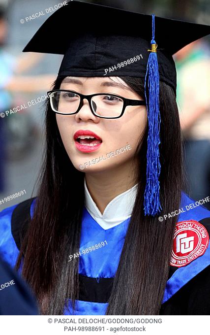 Young Asian university student wearing cap and gown. Ho Chi Minh City. Vietnam. | usage worldwide. - Ho Chi Minh City/Vietnam