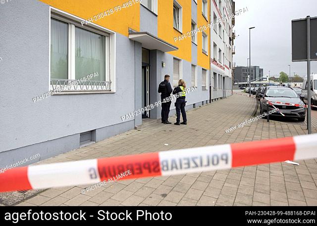 28 April 2023, North Rhine-Westphalia, Duisburg: Police officers stand outside the house in Duisburg. A 53-year-old woman suffered life-threatening injuries in...