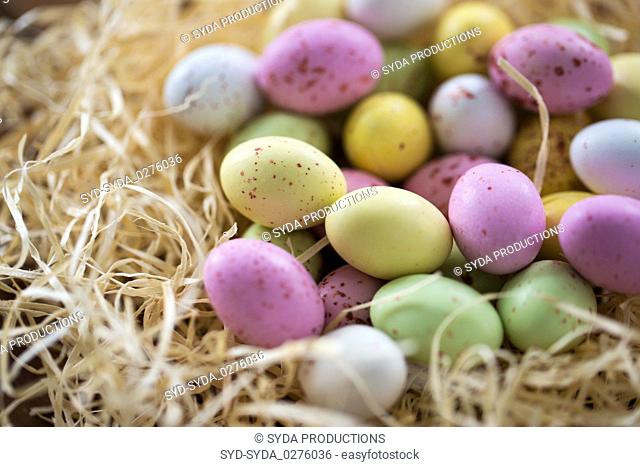 close up of easter egg candies in straw nest