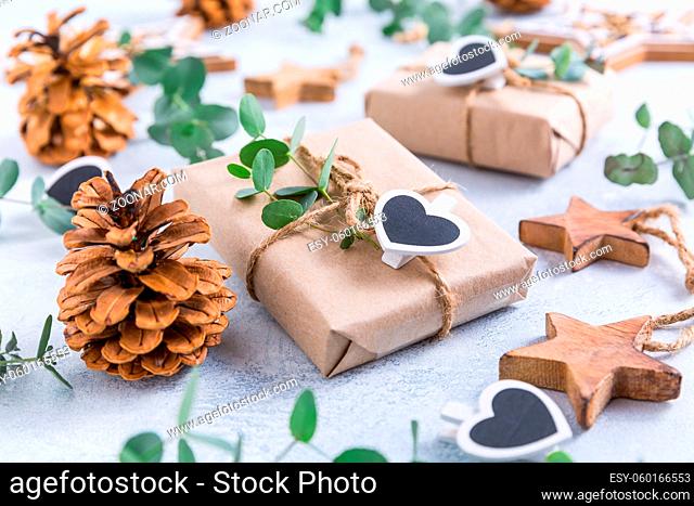 Holiday Christmas Gifts with Boxes, Coniferous, eucalyptus and ornaments on snowy background