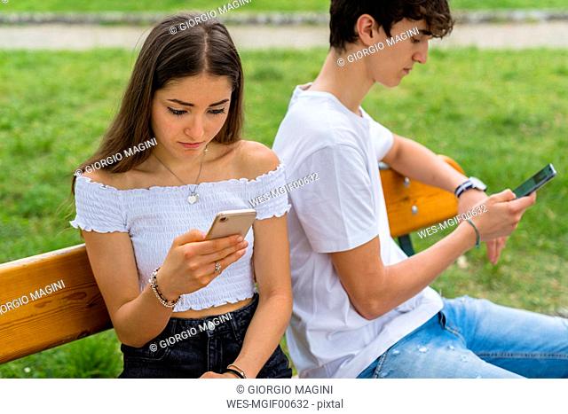 Young couple using smartphone in a park