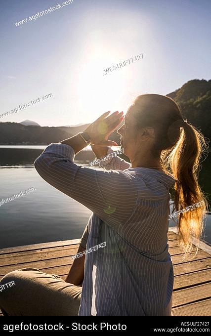 Woman doing yoga with hands clasped on vacation
