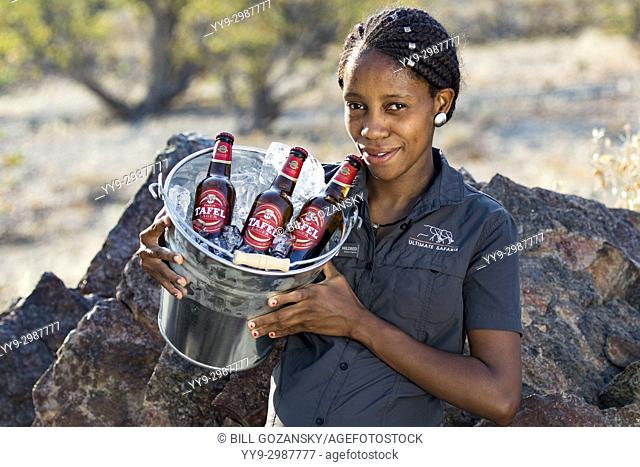 Lodge staff carrying bucket of beer - Huab Under Canvas, Damaraland, Namibia, Africa