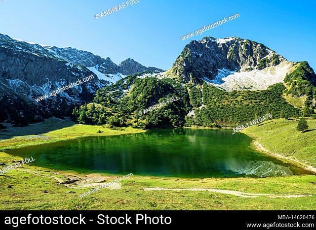 Picturesque lake surrounded by snow-capped mountains on sunny autumn day. Gaisalpsee with Rubihorn, Allgäu Alps, Bavaria, Germany, Europe
