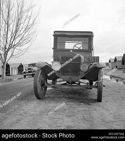 Model T Fords still carry migrants, FSA migratory labor camp at Farmersville, CA, 1939. Creator: Dorothea Lange