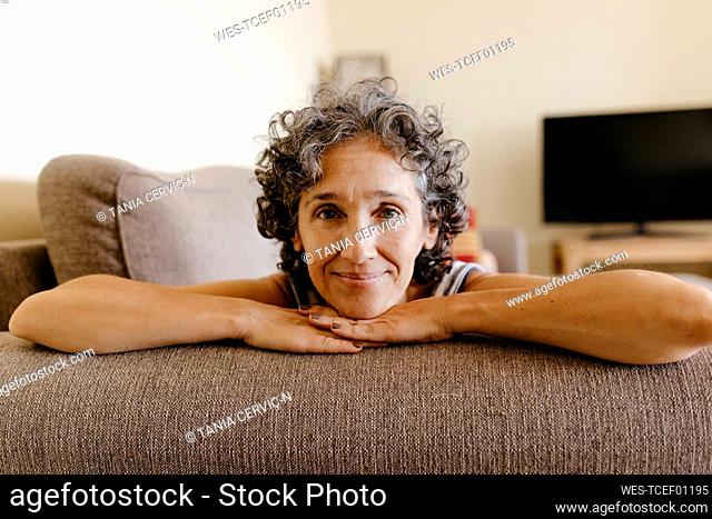Mature woman resting on sofa at home