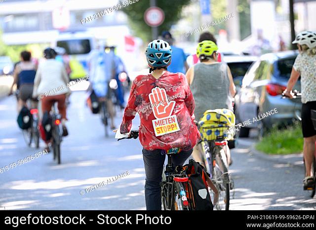 19 June 2021, Hamburg: A demonstrator carries a placard with the inscription ""Rent freeze"" on her back. Around two dozen people took part in a bicycle...