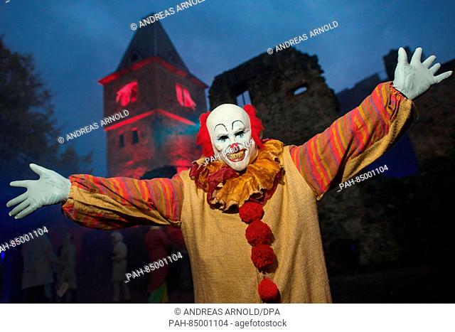 A visitor costumed as the clown ""Pennywise"" from Steven King's ""It"" stands in front of the castle Frankenstein at the Halloween spectacle in Muehltal