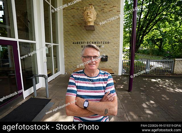 PRODUCTION - 07 July 2022, Hamburg: Janitor André Schulz stands in front of the entrance to the Albert Schweitzer Gymnasium