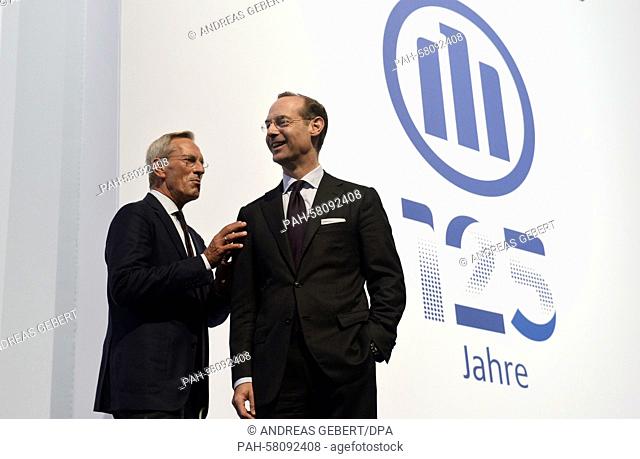 Michael Diekmann (L), outgoing CEO of German insurance company Allianz, and his successor Oliver Baete talk to each other in front of a backdrop with the...
