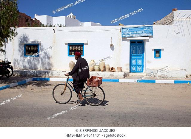 Tunisia, Jerba, Guellala village, Tunisian cycling in front of a pottery shop
