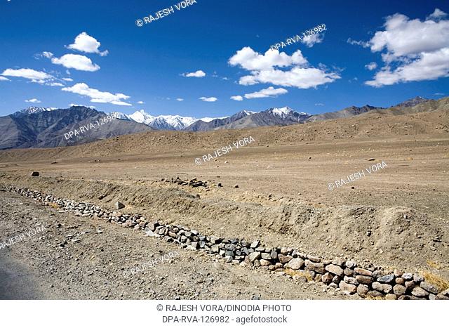 Typical landscape of Ladakh with sandy rocky and snow covered mountains on Leh Kargil road ; Ladakh ; Jammu and Kashmir ; India