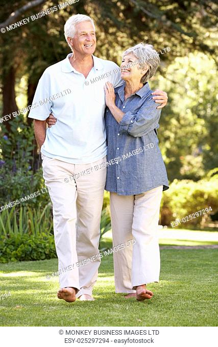 Senior Couple Walking In Garden At Home