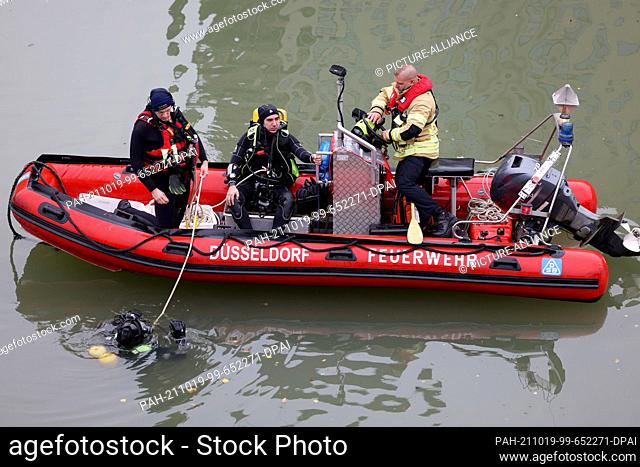 19 October 2021, North Rhine-Westphalia, Duesseldorf: Fire brigade divers prepare to rescue a car from the harbour basin