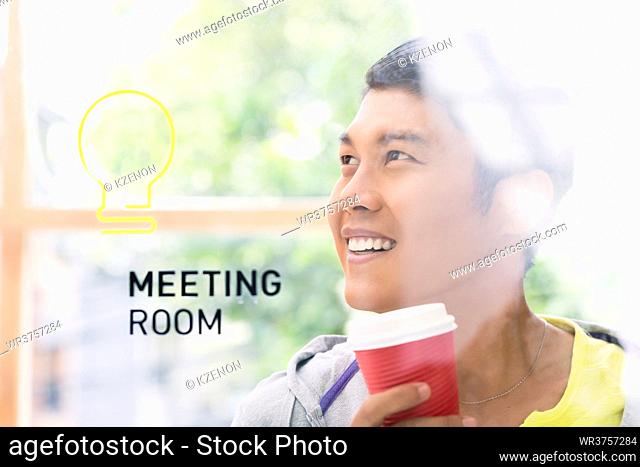 Portrait of creative young Asian employee smiling while thinking of innovative business ideas in the meeting room